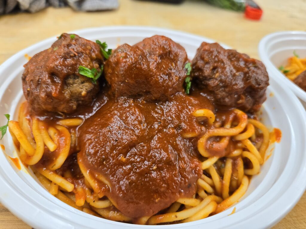 A plate of spaghetti topped with meatballs and marinara sauce, garnished with parsley.