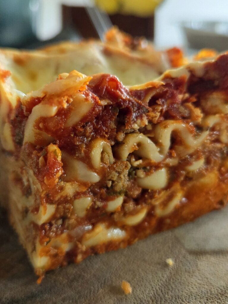 A close-up of a slice of lasagna with layers of pasta, meat, and sauce.