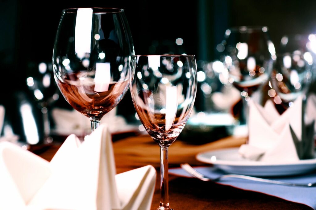 Elegant dining setup with wine glasses, folded napkins, and a beautifully arranged table.
